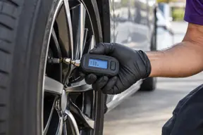 A digital pressure gauge on a tire’s valve stem