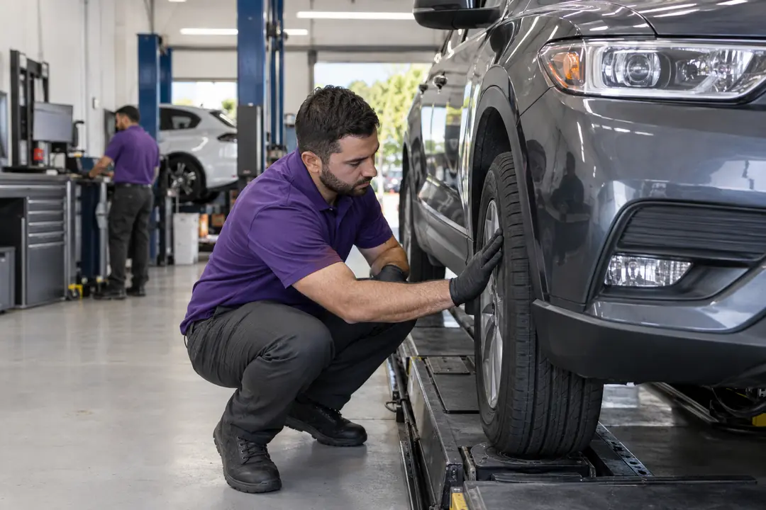 A technician running his palm across a front tire’s tread