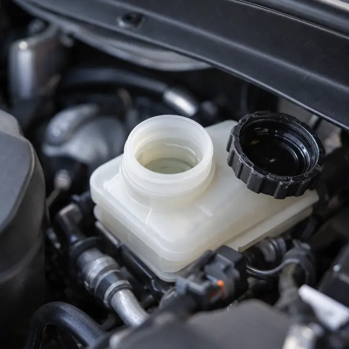 An open brake fluid reservoir with clear fresh fluid
