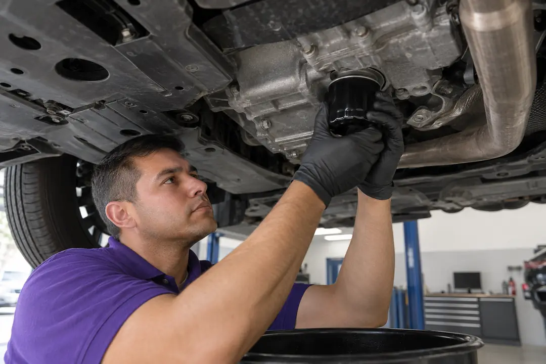 Gloved hands fitting a new oil filter