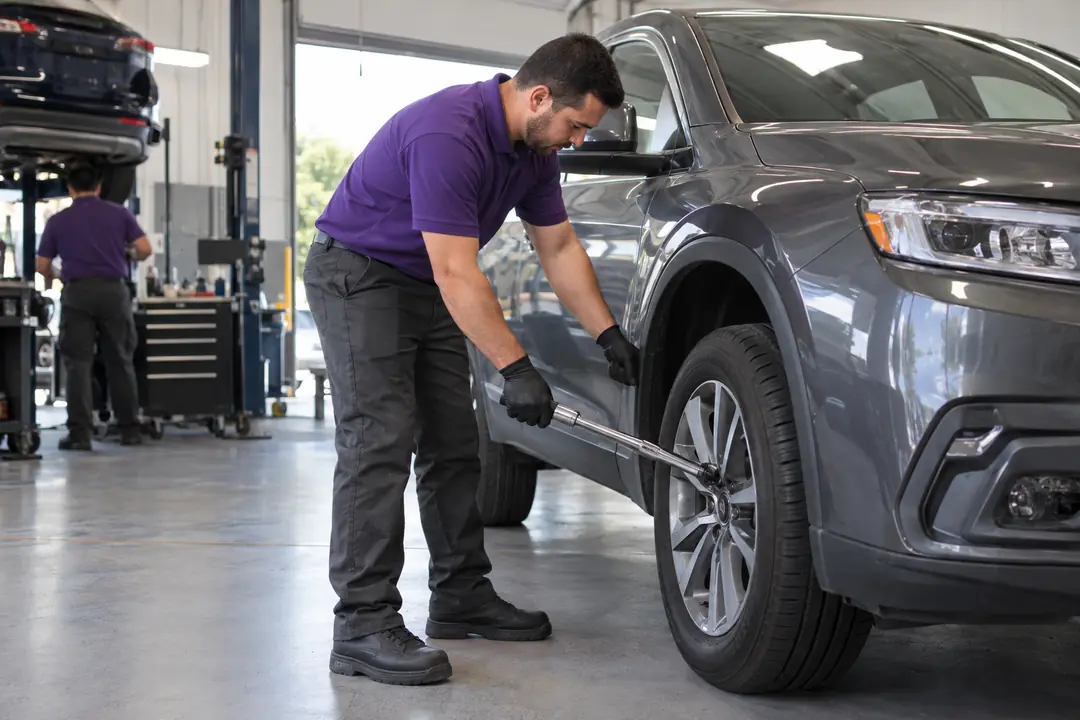 A technician tightening lug nuts with a torque wrench